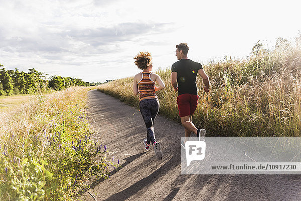 Young couple running on country lane