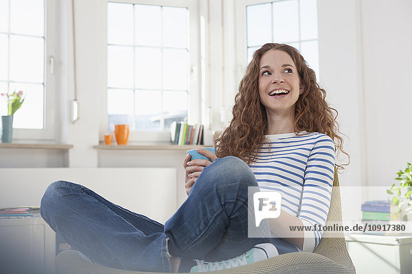 Smiling woman at home sitting in chair