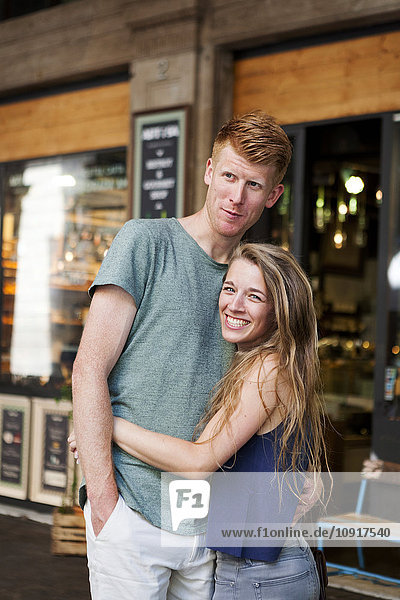 Portrait of happy couple standing in front of a coffee shop