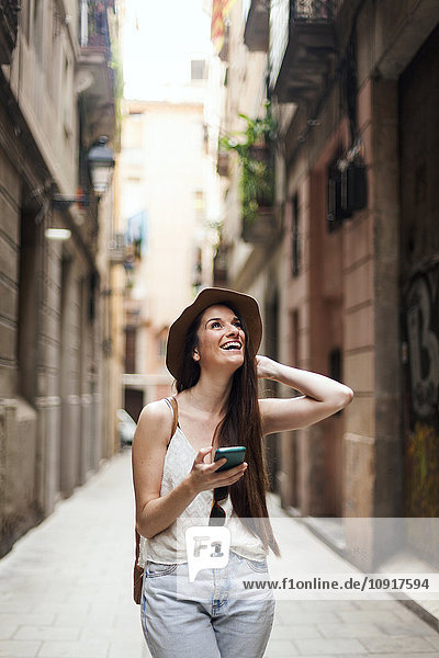 Young tourist discovering streets of Barcelona  using mobile phone