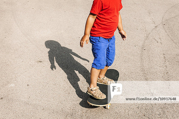 Kleiner Junge auf Skateboard stehend  Teilansicht