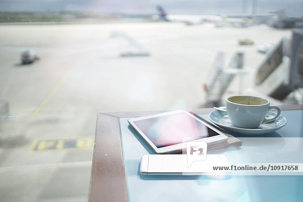 Kaffeetasse  Smartphone und digitales Tablett auf dem Tisch am Flughafen
