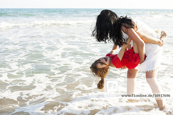 Mutter spielt mit ihrer kleinen Tochter an der Strandpromenade