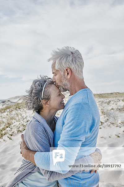 Ein glückliches Paar  das sich am Strand umarmt.