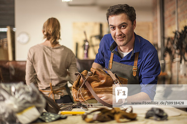Porträt des lächelnden Mannes in der Lederwerkstatt