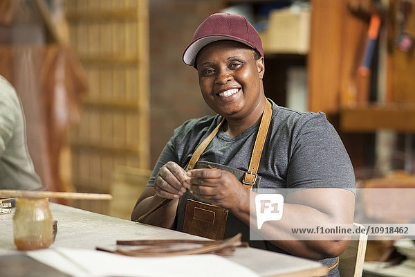 Porträt einer lächelnden Frau in der Lederwerkstatt