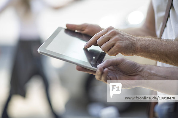 Zwei Männer teilen sich ein digitales Tablett im Freien