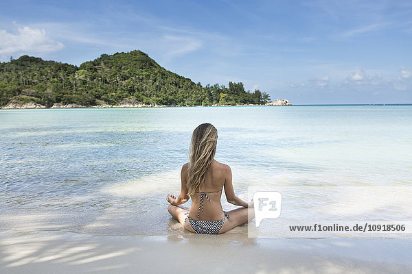Thailand  Frau beim Meditieren am Strand