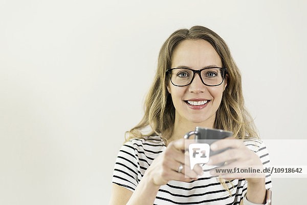 Porträt einer lächelnden Frau mit einer Tasse Kaffee