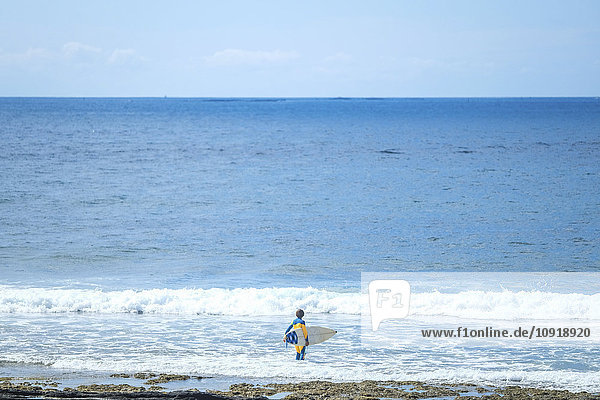 Spain  Tenerife  boy with surfboard in the sea