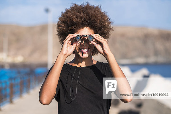 Smiling young woman with binocular