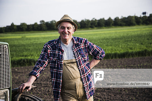 Porträt eines lächelnden Bauern vor einem Feld