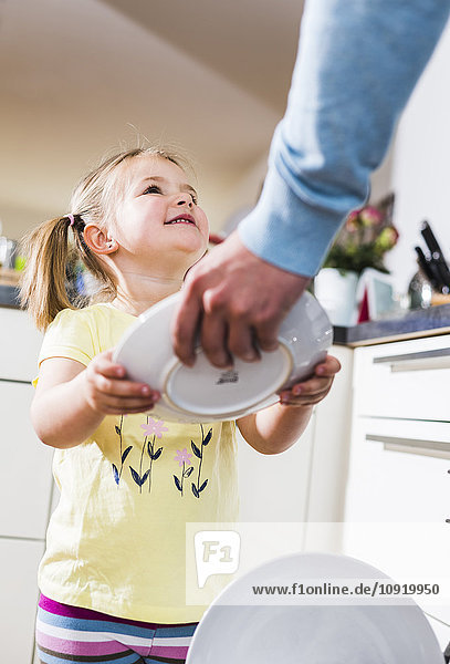 Tochter hilft Vater beim Geschirrspülen
