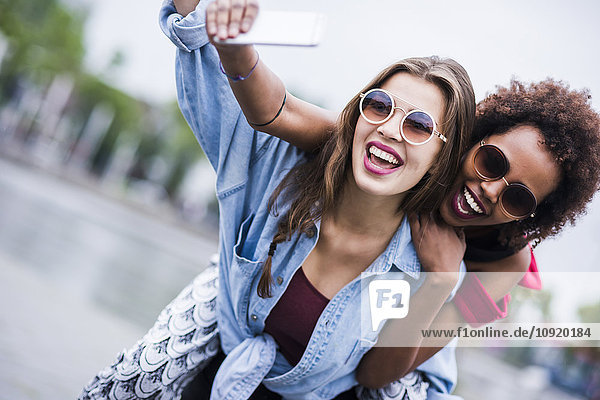 Porträt von zwei glücklichen besten Freunden  die Selfie mit dem Smartphone nehmen.
