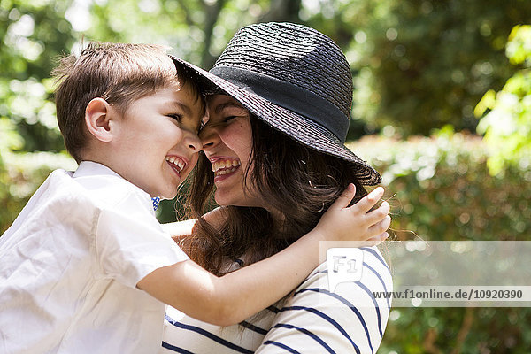 Happy mother and son hugging outdoors