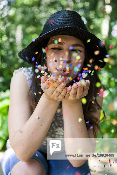 Young woman playing with confetti
