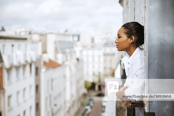 Frankreich  Paris  junge Frau auf dem Dachboden aus dem Fenster lehnend