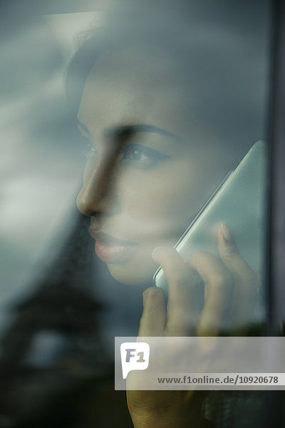 Frankreich  Paris  junge Frau beim Telefonieren durch das Autofenster schauend