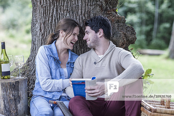 Glückliches junges Paar beim Picknick mit Weißwein