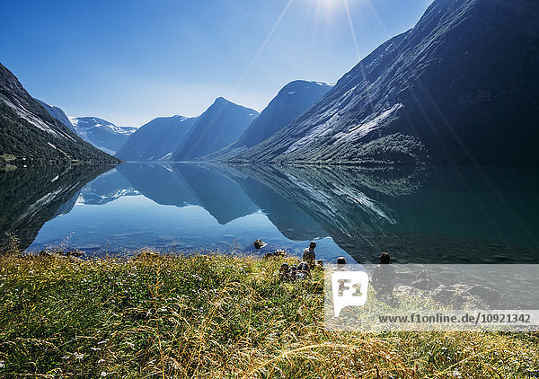 Freunde entspannen sich am sonnigen  ruhigen Bergseeufer  Norwegen