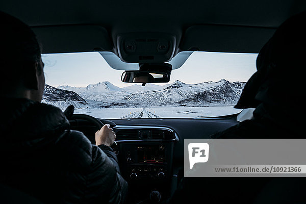 Männer fahren Auto durch verschneite Landschaften  Island