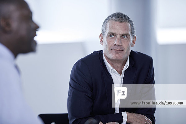 Attentive businessman listening to colleague in meeting
