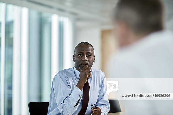 Serious businessman listening to colleague in meeting