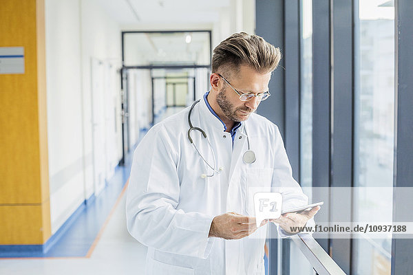 Doctor in medical clinic using digital tablet