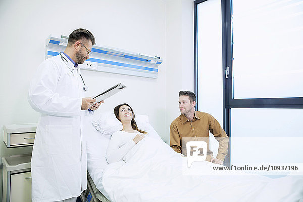 Doctor with patient in sick room of hospital