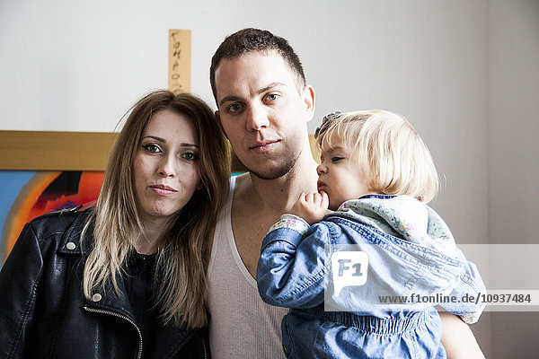 Portrait of couple with daughter in art studio