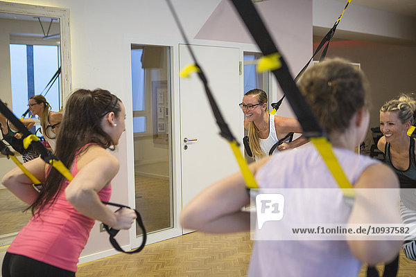 Women in exercise class doing suspension training