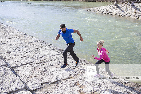 Young couple exercising by the riverside