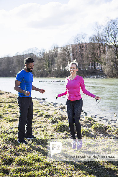 Young couple skipping by the riverside