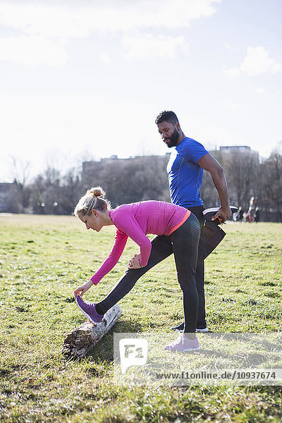 Young couple stretching in city park