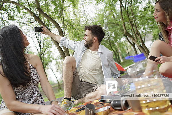 Friends taking a selfie at campsite