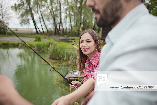 Young couple fishing together in lake