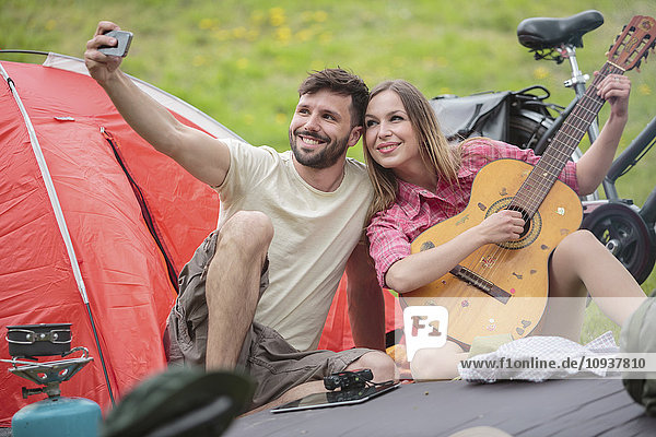 Young couple at campsite taking selfie