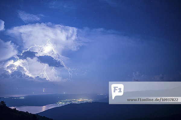 Lightnings in thunderstorm over coastline at night