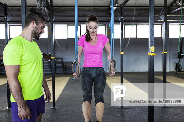 Woman doing gym exercise on rings in gym