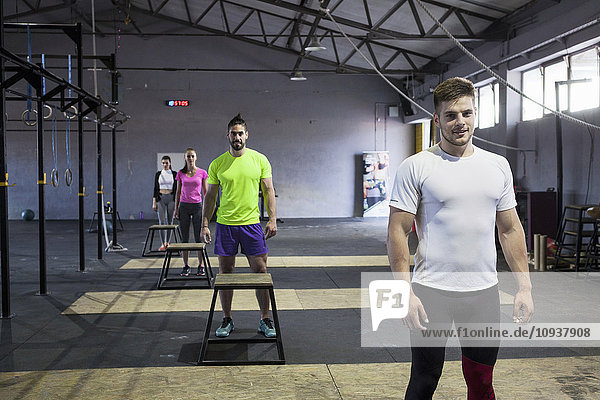 Athletes prepare for doing box jumps in gym
