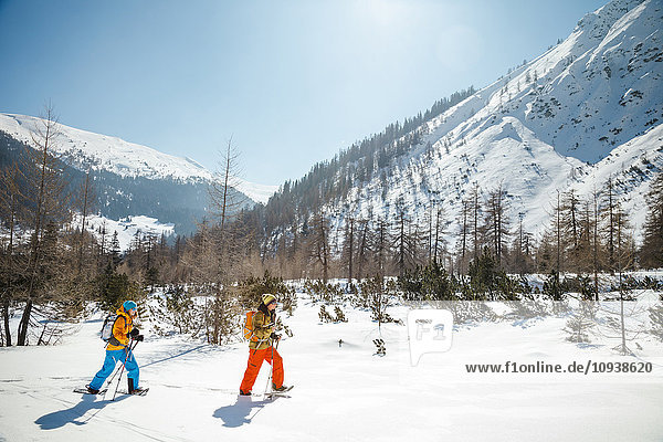 Two people snowshoeing in Alpine scenery