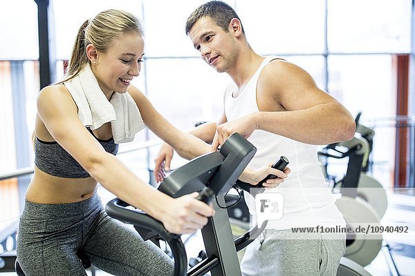 Man instructing woman in gym