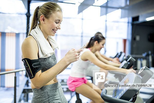 Woman using phone in gym