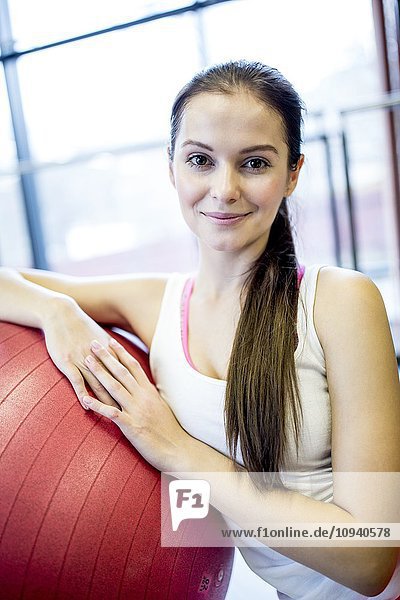 Young woman leaning on fitness ball