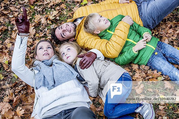 Familie auf getrockneten Blättern liegend