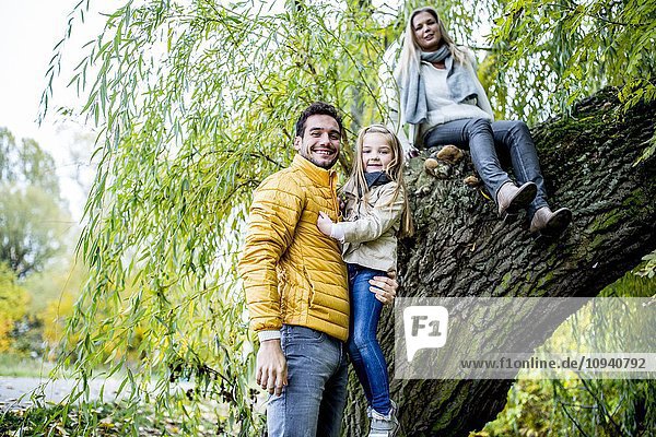 Vater trägt Tochter in der Nähe des Baumes