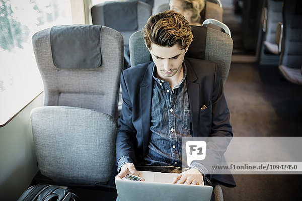 Geschäftsmann mit Laptop im Zug