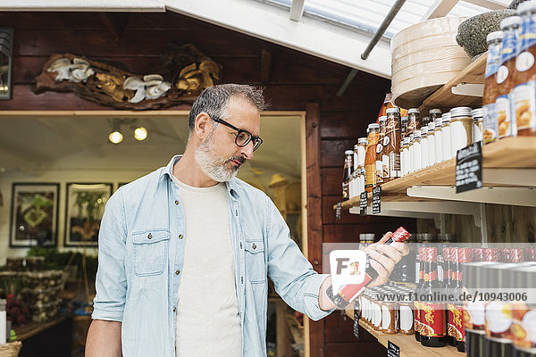 Reifer Mann beim Einkaufen in der Flasche