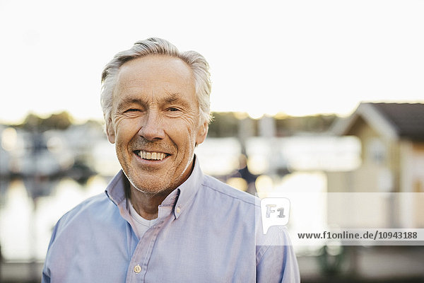 Portrait of confident senior man smiling outdoors