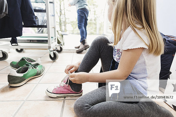 Mädchen mit Schuhen auf dem Boden der Kindertagesstätte